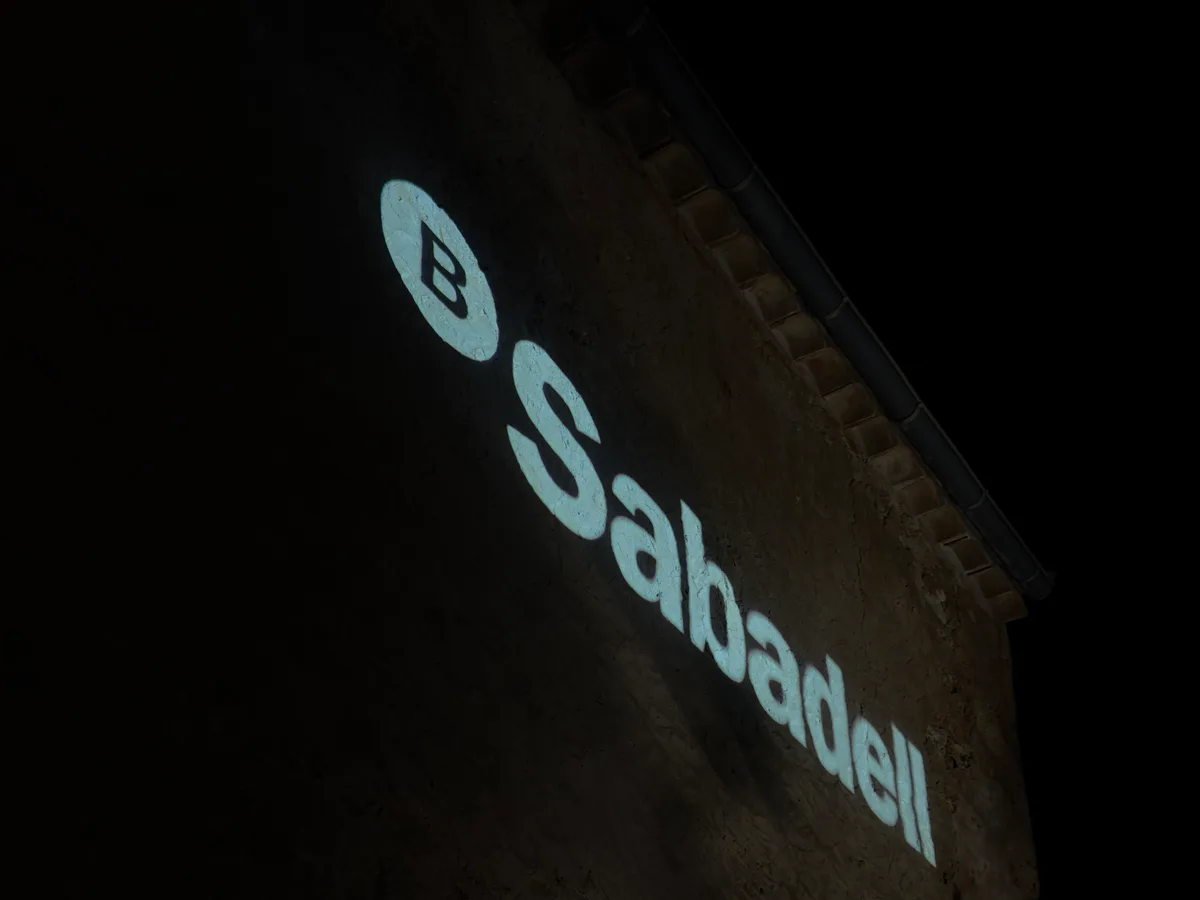 Logo von Banco Sabadell, bei einem Firmenevent auf eine Steinfassade projiziert