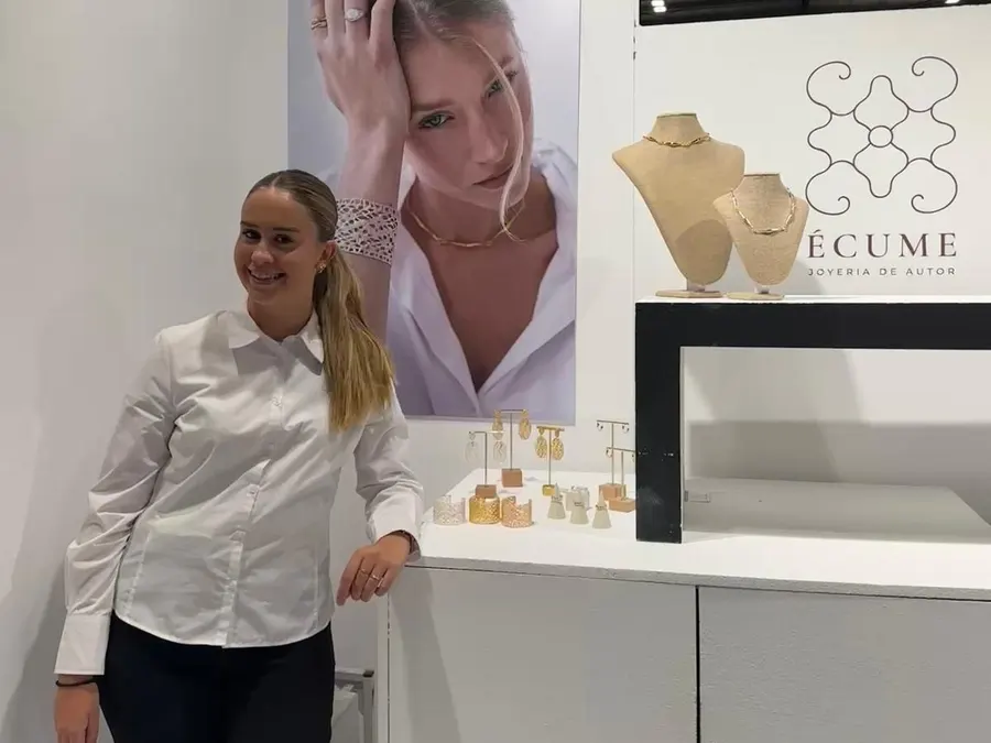 Azafata atendiendo el stand de una joyería en una feria