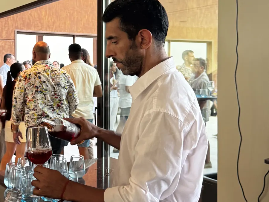 Bartender sirviendo vino tinto en la barra de un evento