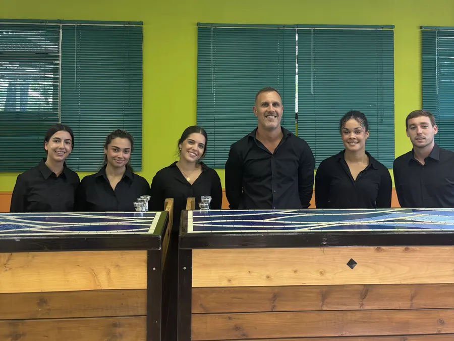 Equipo de bartenders detrás de la barra antes del servicio