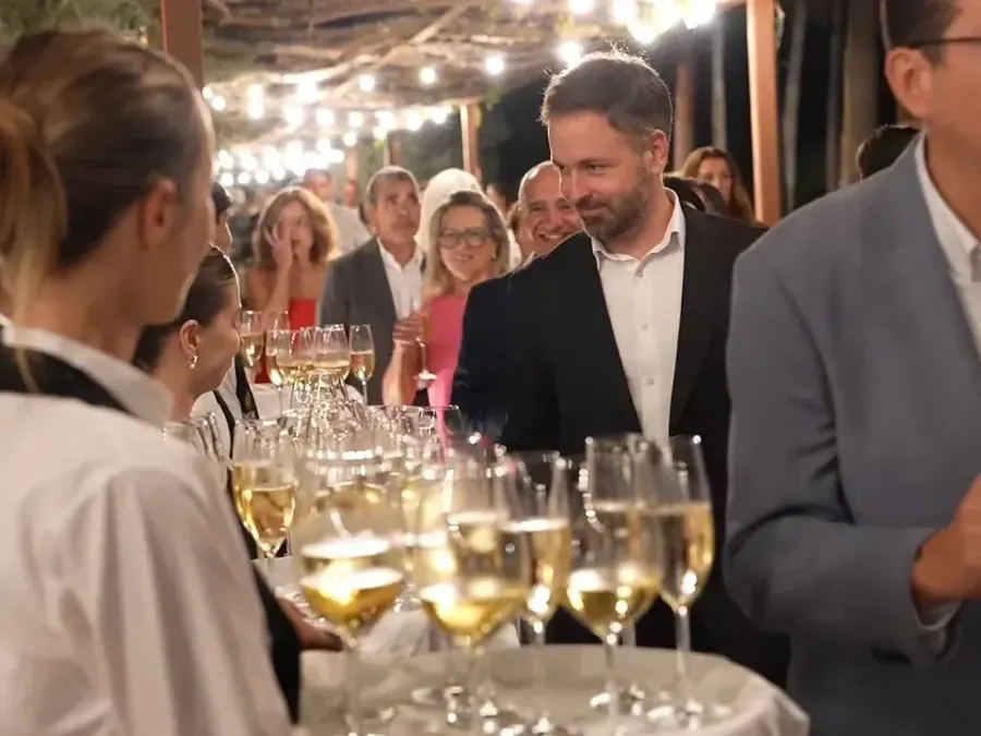 Camarera ofreciendo cava a los invitados a su llegada