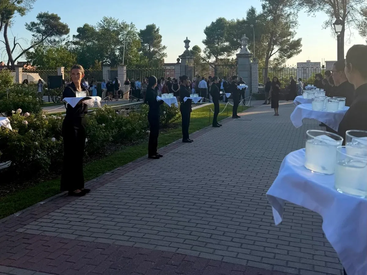 Camareras de Grupo Picolín con bandejas de bebida recibiendo a los invitados en un jardín