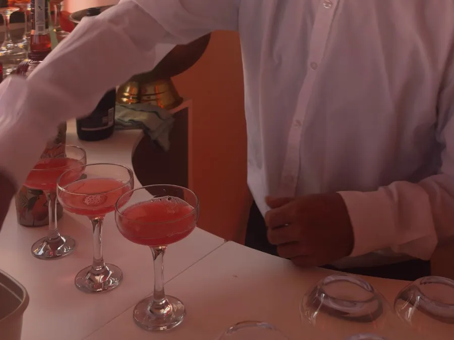 Coctelero sirviendo cócteles en copas de cóctel