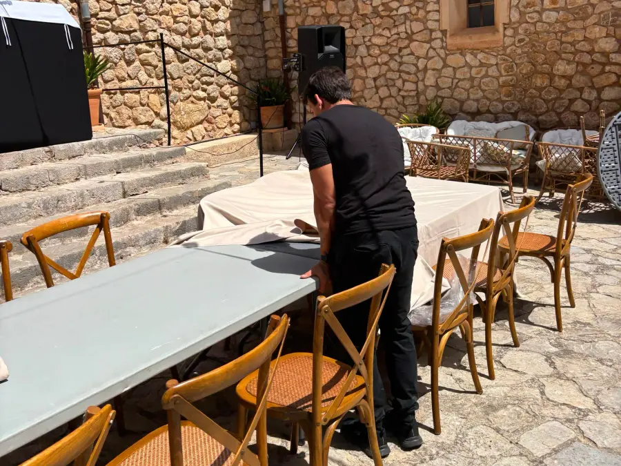 Montador preparando las mesas en el patio de una finca